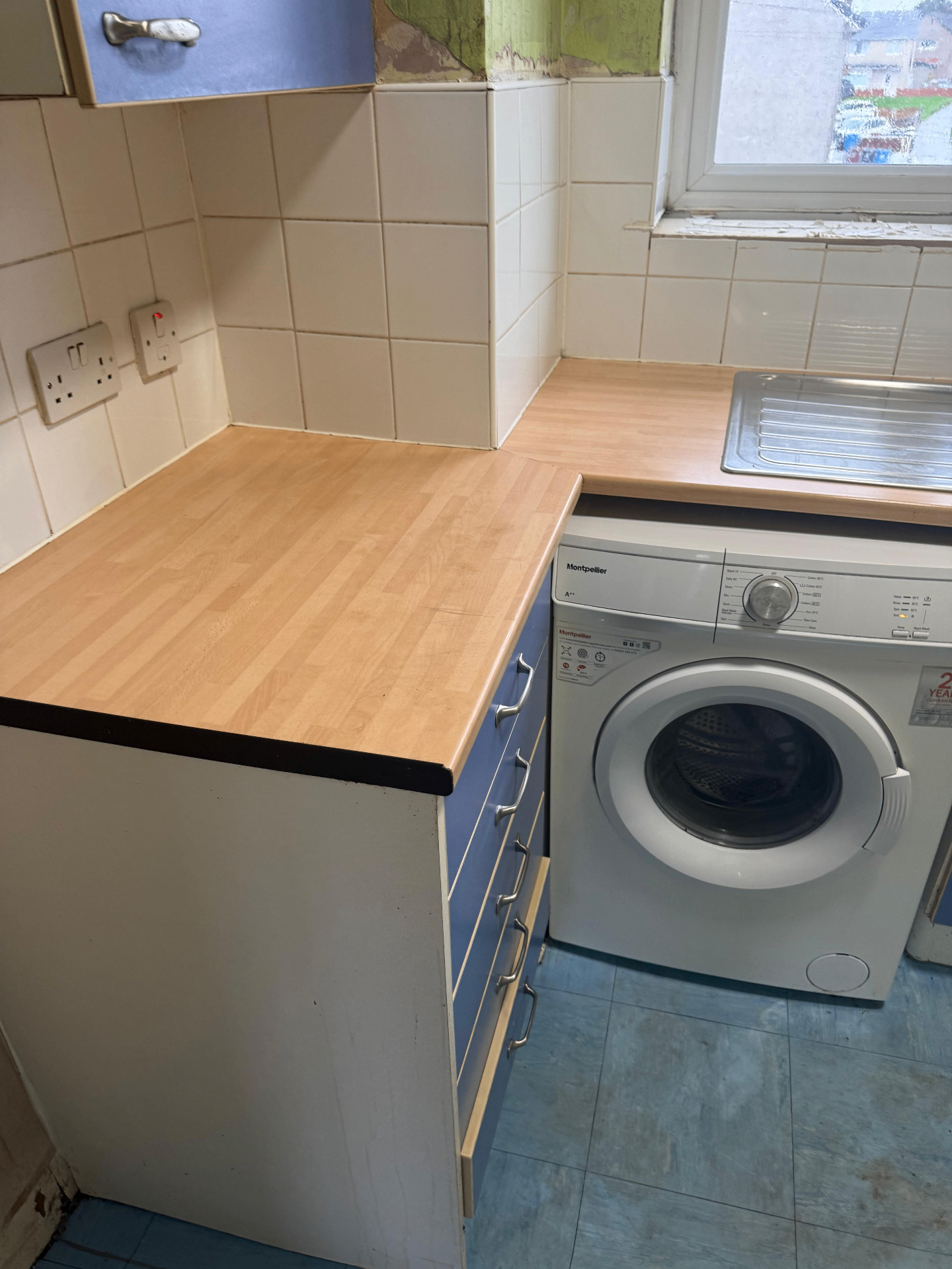Cleared kitchen worktop and washing machine area after hoarder clearance