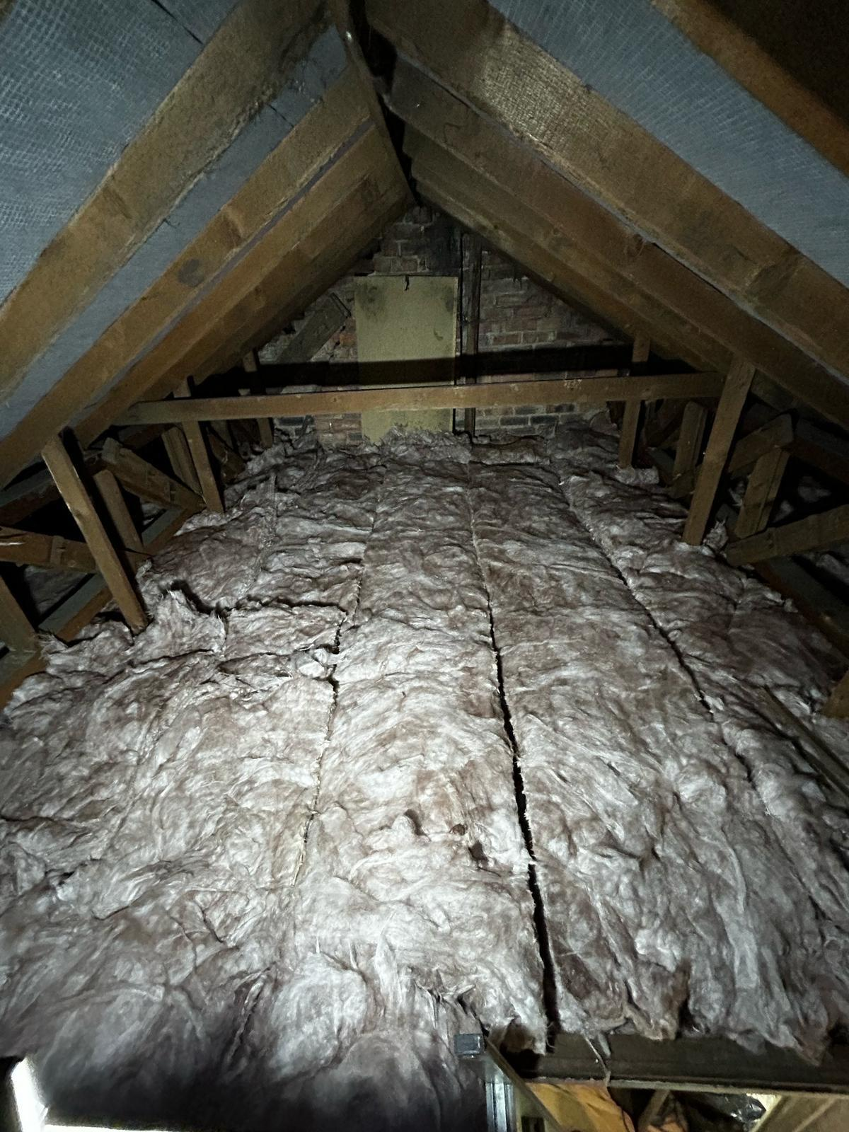 Old loft insulation in a residential attic